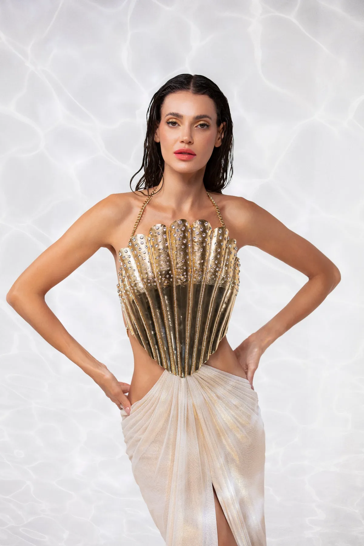 Gold-plated scallop shell corset handcrafted from solid brass and studded with crystals, worn with a draped skirt in gold foiled silk tulle