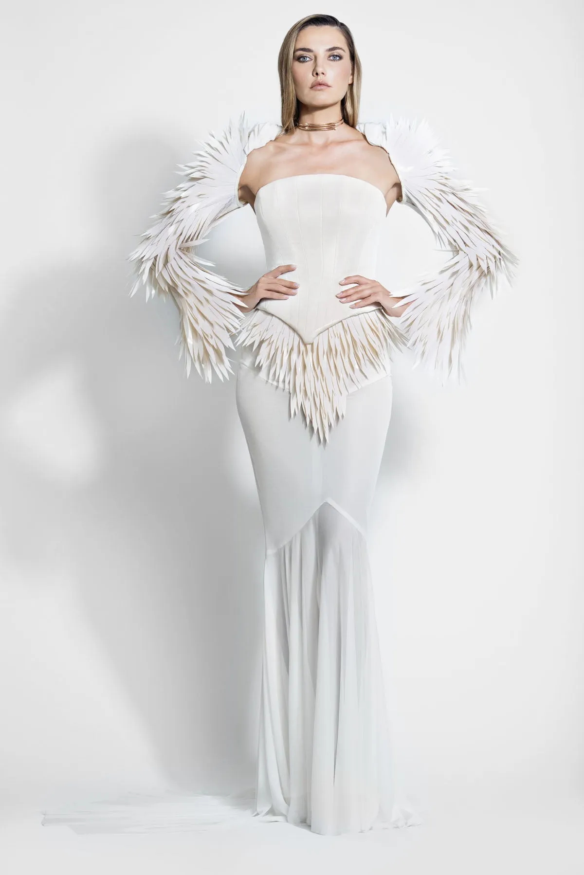 Ivory corseted bustier accompanied with a hooded bolero jacket embellished with 3D laser-cut plumes and a skirt in silk jersey